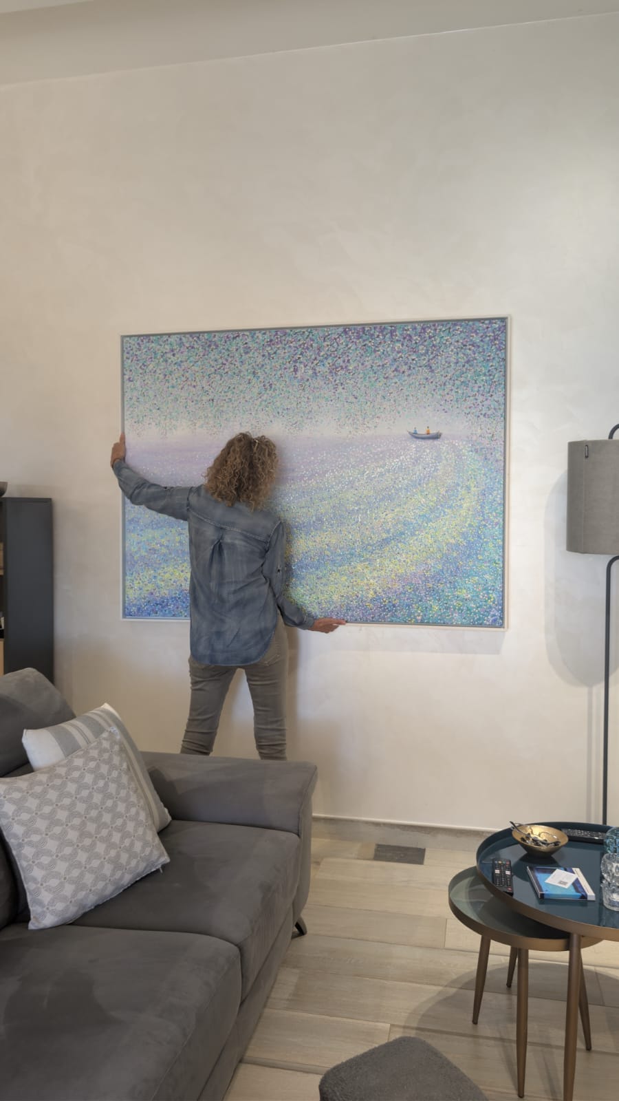 Emanuela Orler sistema un’opera di Je Shen in casa cliente
